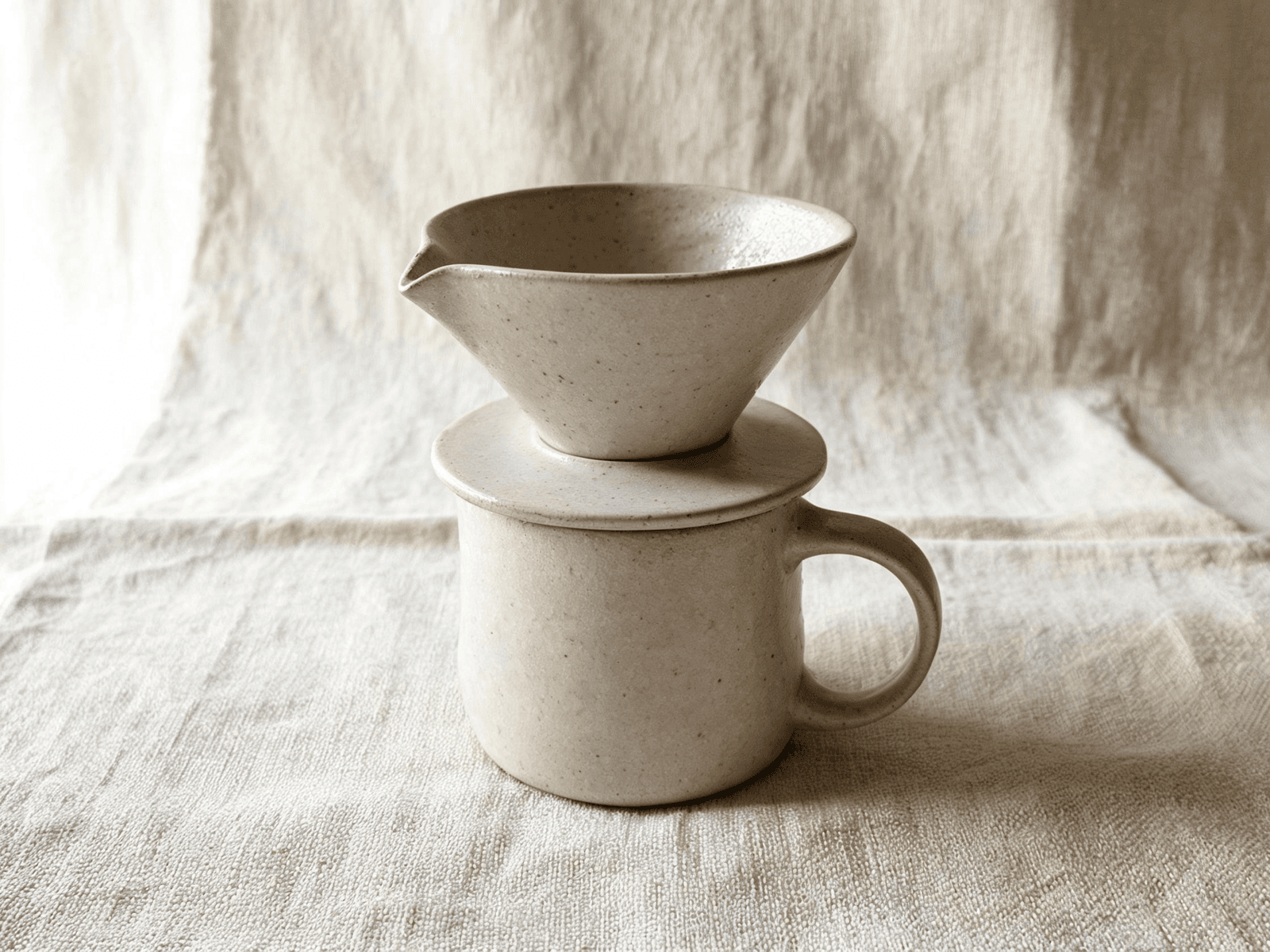 Handmade stoneware pour-over set in oatmeal glaze on raw linen