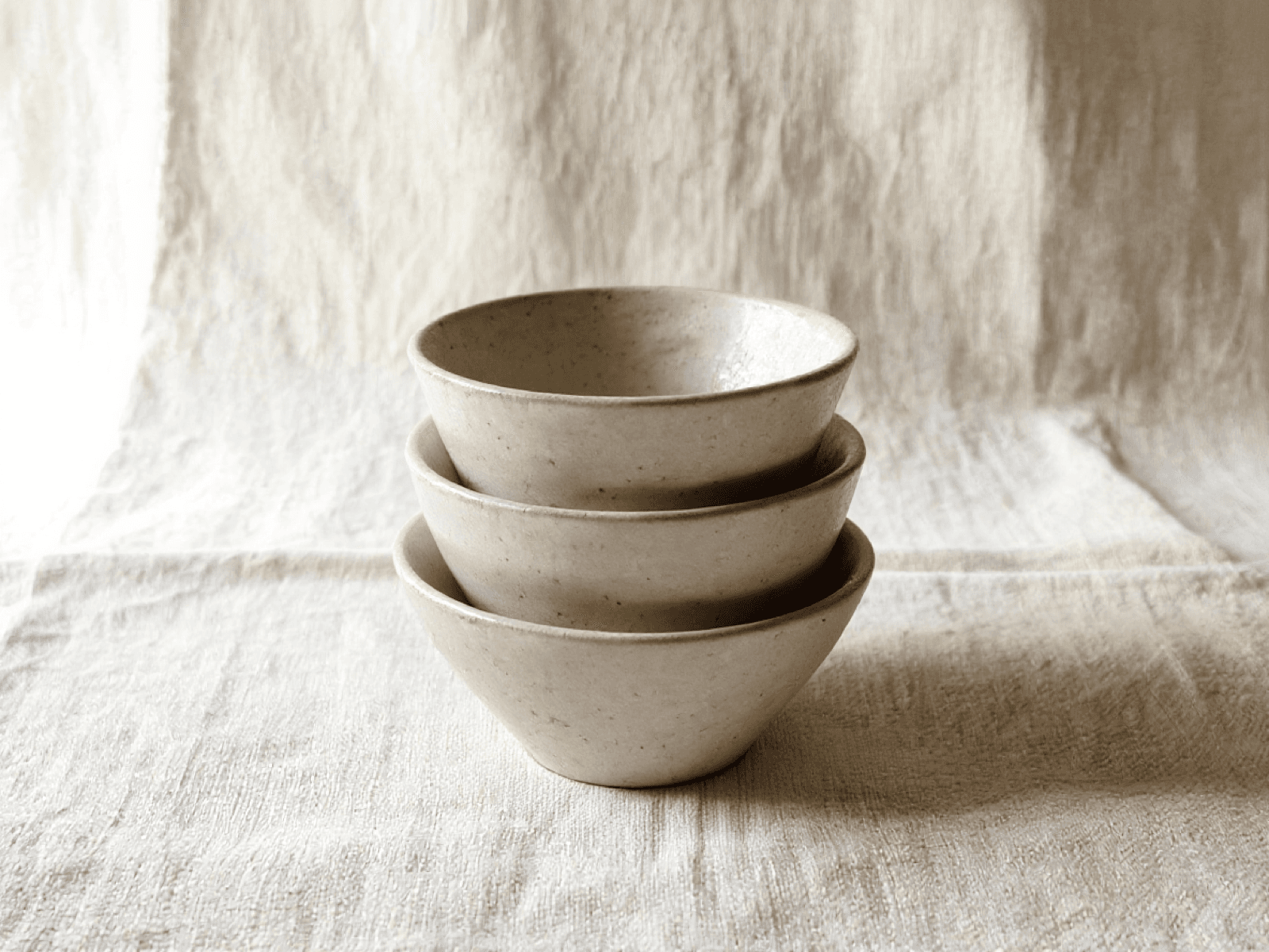 Three nesting stoneware bowls stacked slightly offset