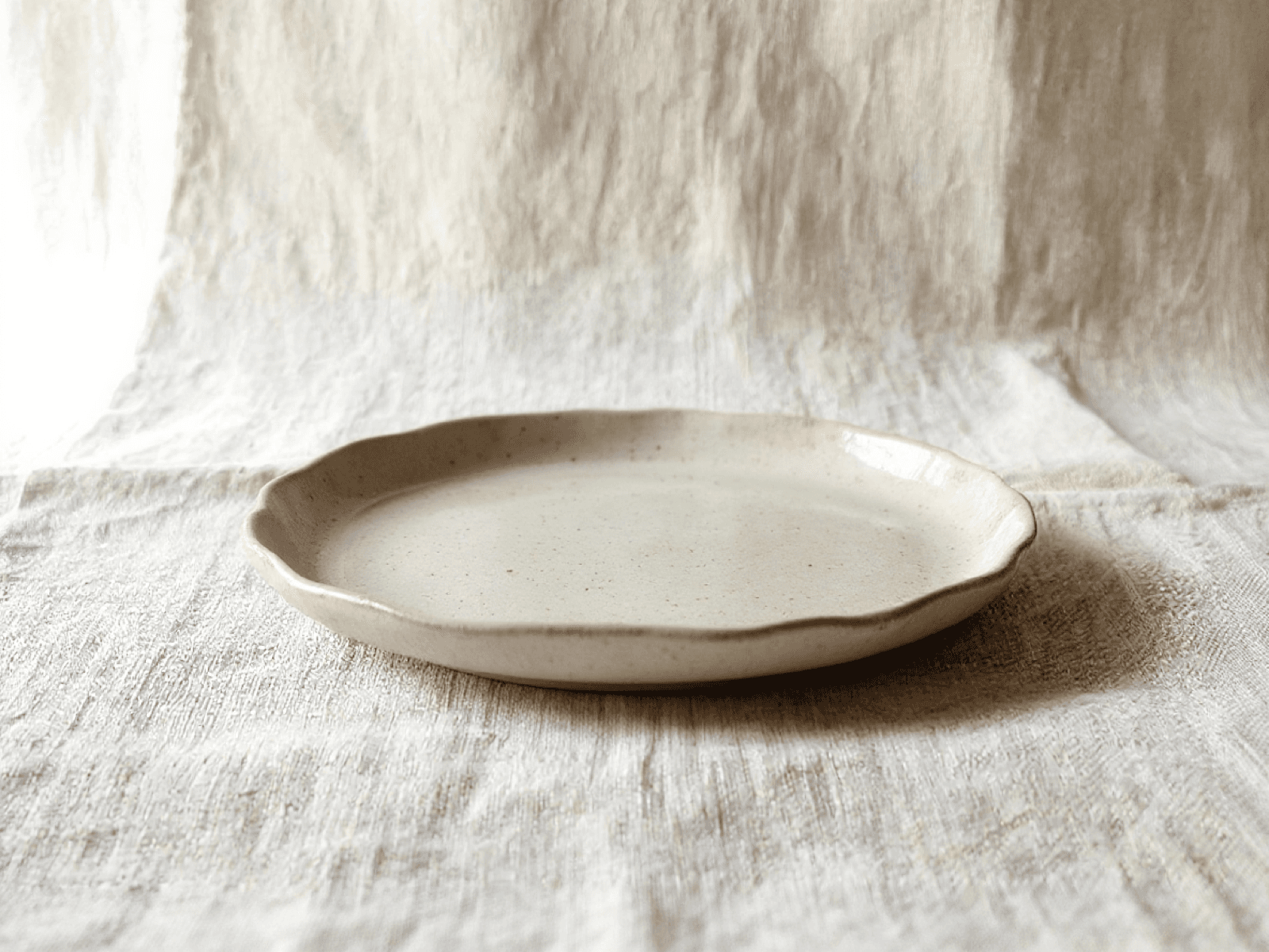 Long oval stoneware serving platter with a hand-formed wavy rim